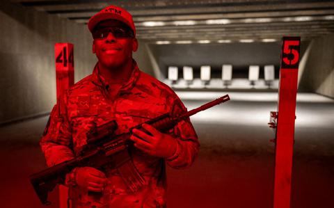 Photo Of Senior Airman Orlin Loving with a gun poses for a photo.