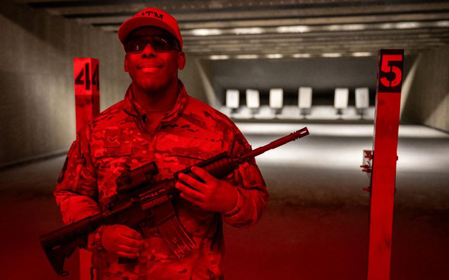 Senior Airman Orlin Loving with a gun poses for a photo.