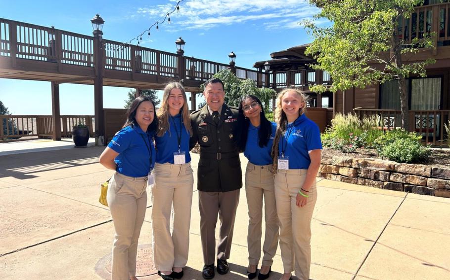 Bella Hunter, second from left; Aaliya Ismail, second from right; and Emerson Moore, right; pose for a photo with Col. John S. Chu, center, executive officer to the Commanding General of U.S. Army Installation Management Command; and Hannah Maza, left, director of the Camp Zama Youth Center, during the Youth Leadership Forum held June 20 through 28 in Colorado Springs, Colorado. 