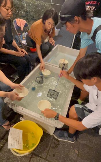 People are enjoying goldfish scooping.