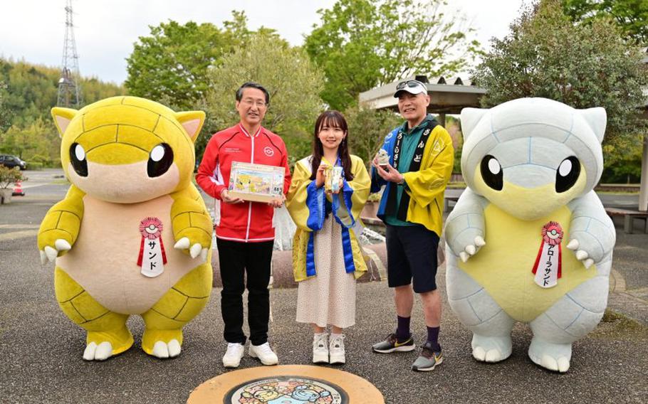 3 people and two costumed people pose for a photo.