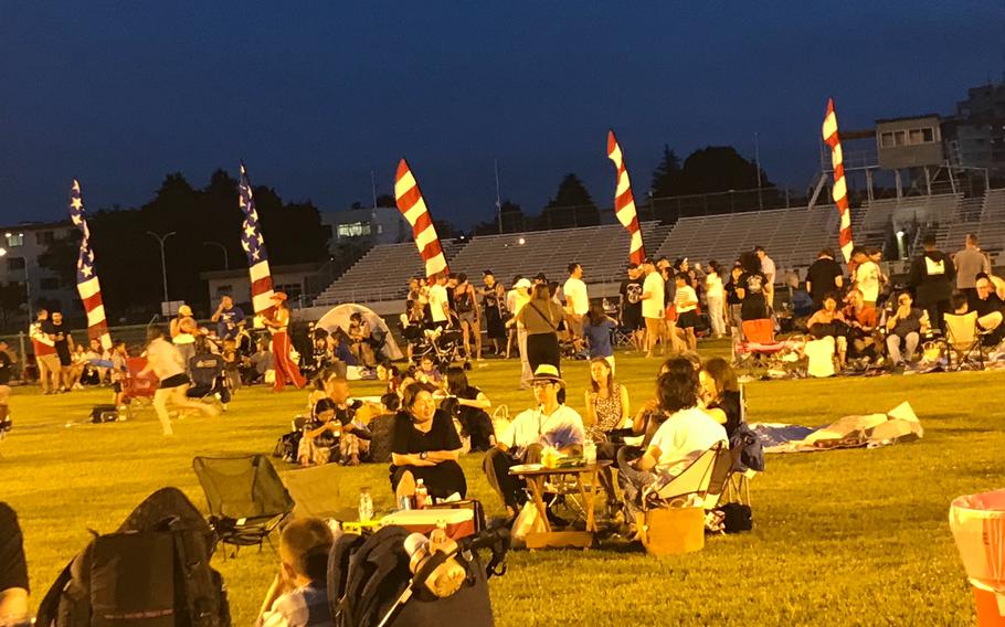 Visitors are having seat on the lawn at night.