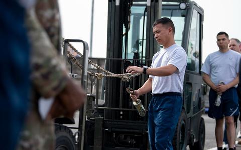 Photo Of Tech. Sgt. Ephraim Oliva installs a device on a chain.