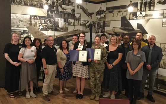 Photo Of Misawa Club staff group photo as Stars and Stripes Pacific Commander Lt. Col. Marci Hoffman presents award.
