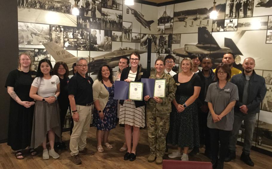 Misawa Club staff group photo as Stars and Stripes Pacific Commander Lt. Col. Marci Hoffman presents award.