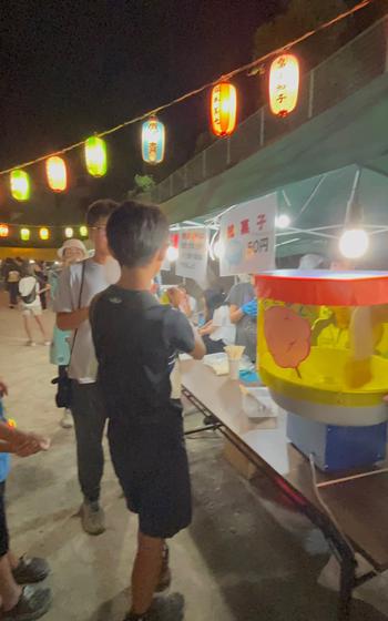 Some people are buying food at a booth.