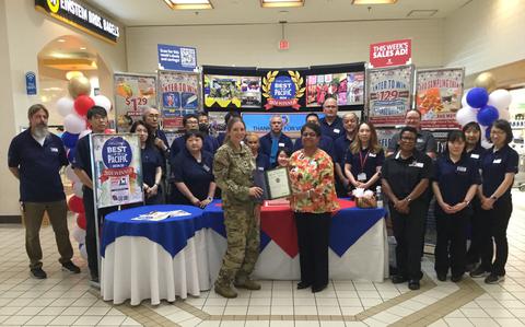 Photo Of Misawa Main Exchange staff group photo as Stars and Stripes Pacific Commander Lt. Col. Marci Hoffman presents award.