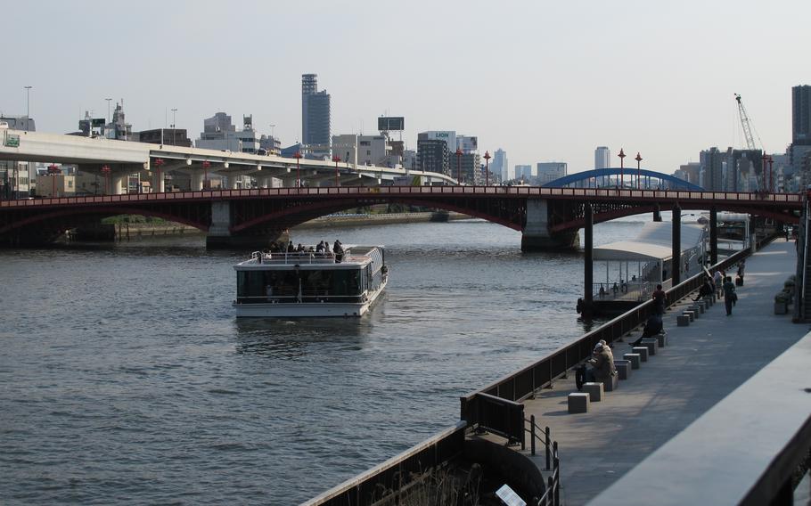 A cruiser is about to sail under a bridge.