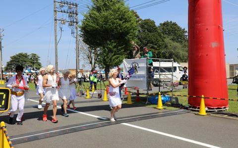 Photo Of Runners in costume take off at the start of the 29th annual East Japan International Friendship Half Marathon April 27 on Sagami General Depot, Japan, while Command Sgt. Maj. Richard Meeker, top right, the senior enlisted leader of U.S. Army Garrison Japan, waves at them.