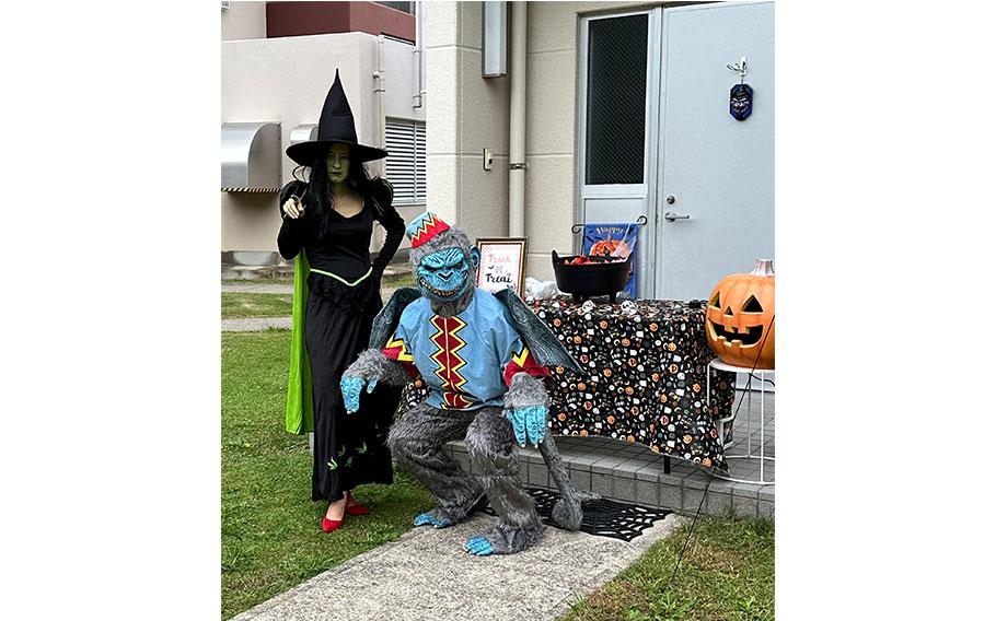 two people wearing costumes in front of a house.