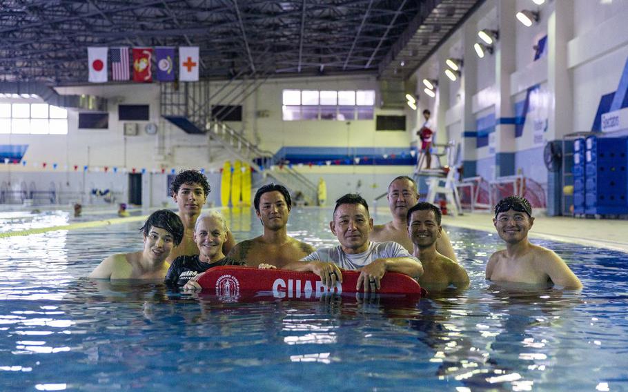 The Marine Corps Air Station Iwakuni Aquatics Team poses for a group photo in the Marine Corps Community Services’ indoor pool on Sept. 4, 2024. Ayers and the MCAS Iwakuni aquatics team provide swim clinics and master classes, and train instructors with the goal to improve service members’ survival skills and increase their water confidence.