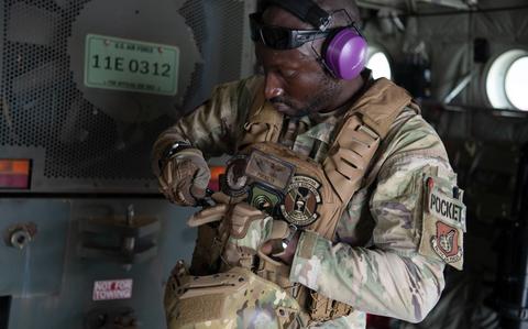 Photo Of Staff Sgt. McArthur Posey secures his protective gear.
