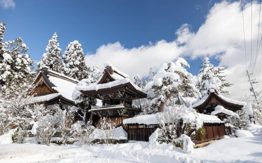 snow piled on a traditional Japanese house.