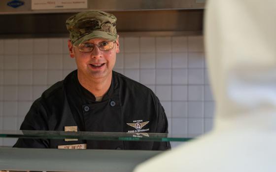 Photo Of Col. Richard McElhaney prepares a meal for an unaccompanied Airman.