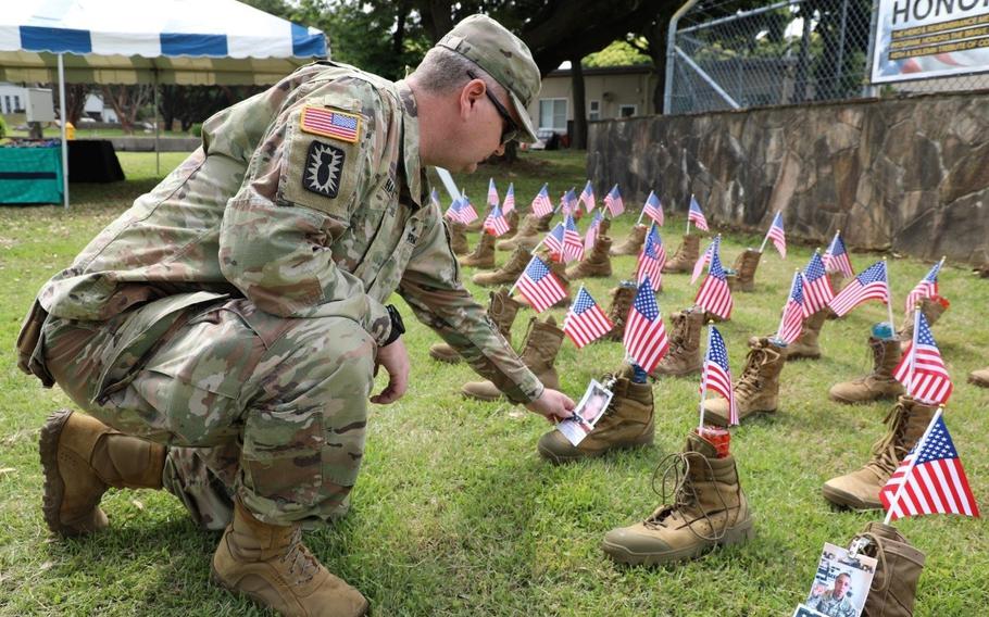 Chief Warfare Officer 2 Ronnie Haddox, assigned to the 5th Transportation Company (Composite Watercraft Company) at Yokohama North Dock, looks at boots on display at the “Hero’s Boots” ceremony held May 16 on Camp Zama in honor of Memorial Day. 