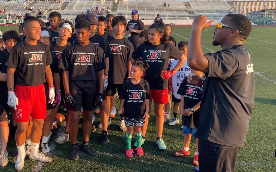 Student athletes listen to a coach.