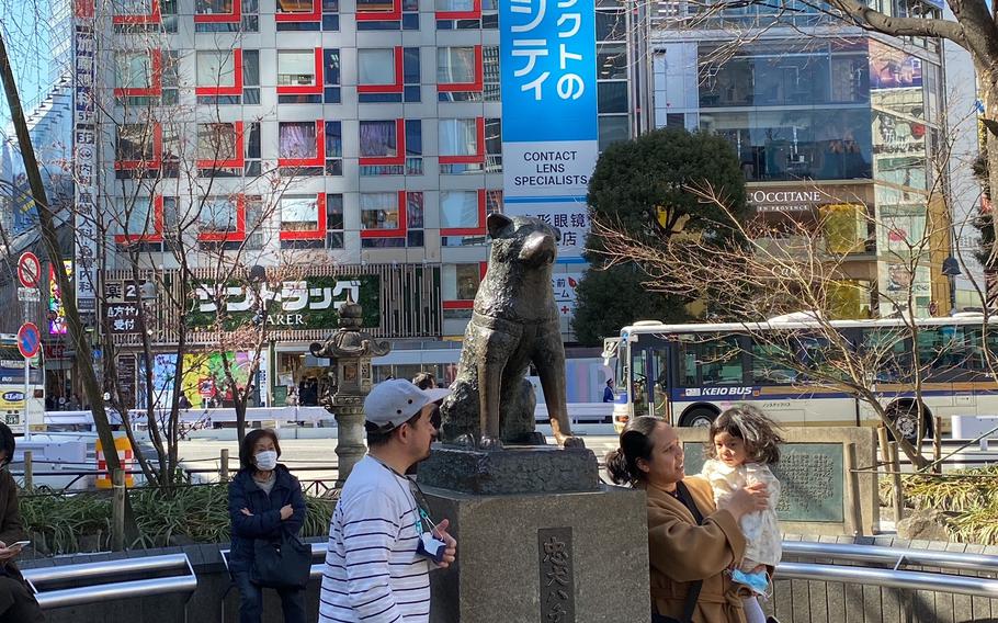 People takes a photo with Statue of Hachi.