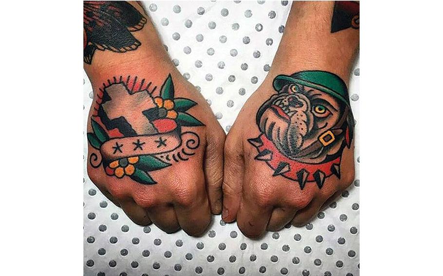 tattoos of a dag and a cross on the backs of one’s hand.