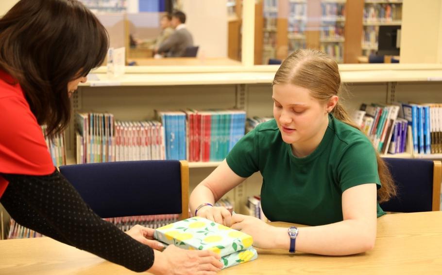 Maribel Sikes, right, practices the Japanese art of handkerchief wrapping known as “furoshiki” March 27 at the Camp Zama Library. This month, Maribel made it as a finalist in 2024’s Operation Homefront Military Child of the Year Award.