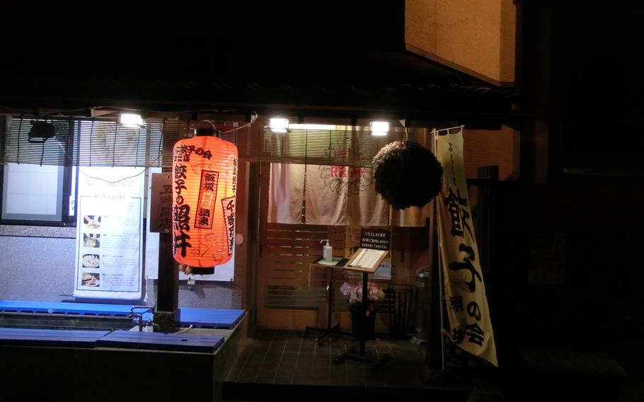 A lantern is hung in the entrance of Gyoza Restaurant Terui at night.