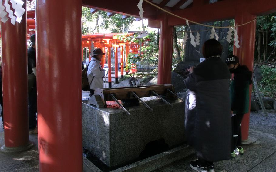 Visitors clean their hands with water at Kinomiya Shrine.