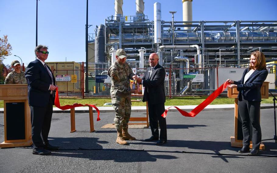 U.S. Air Force Col. Andrew Roddan, 374th Airlift Wing commander and James Potach, Schneider Electric senior vice president of sustainability business, cuts a ribbon to unveil the new power plant at Yokota Air Base, Japan, Nov. 3, 2023. The new power plant is projected to generate over $406 million in guaranteed energy savings over its contact term. 
