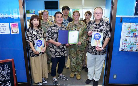 Photo Of Yokota ITT staff group photo as Stars and Stripes Pacific Commander Lt. Col. Marci Hoffman presents award.