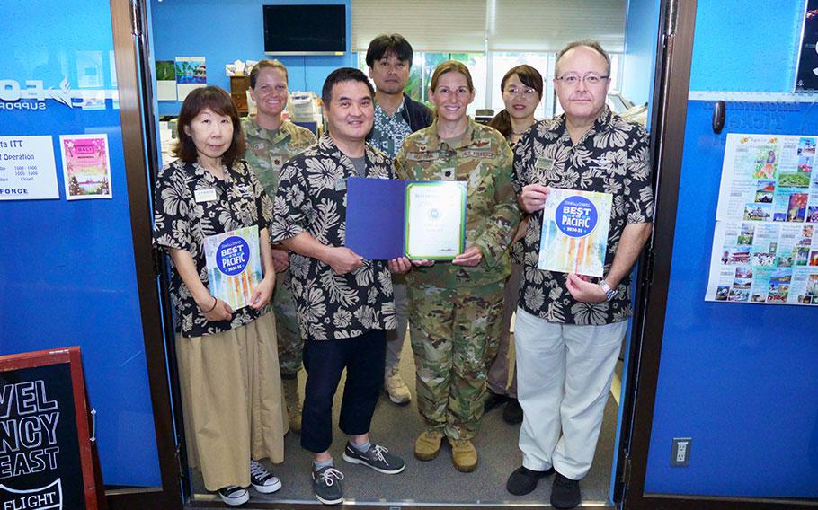 Yokota ITT staff group photo as Stars and Stripes Pacific Commander Lt. Col. Marci Hoffman presents award.