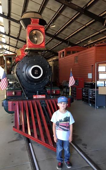 Richard pose in front of a steam train for a photo.