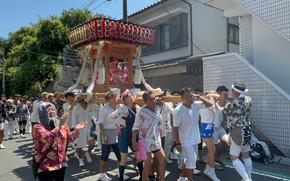 People lift a portable shrine onto their shoulders.
