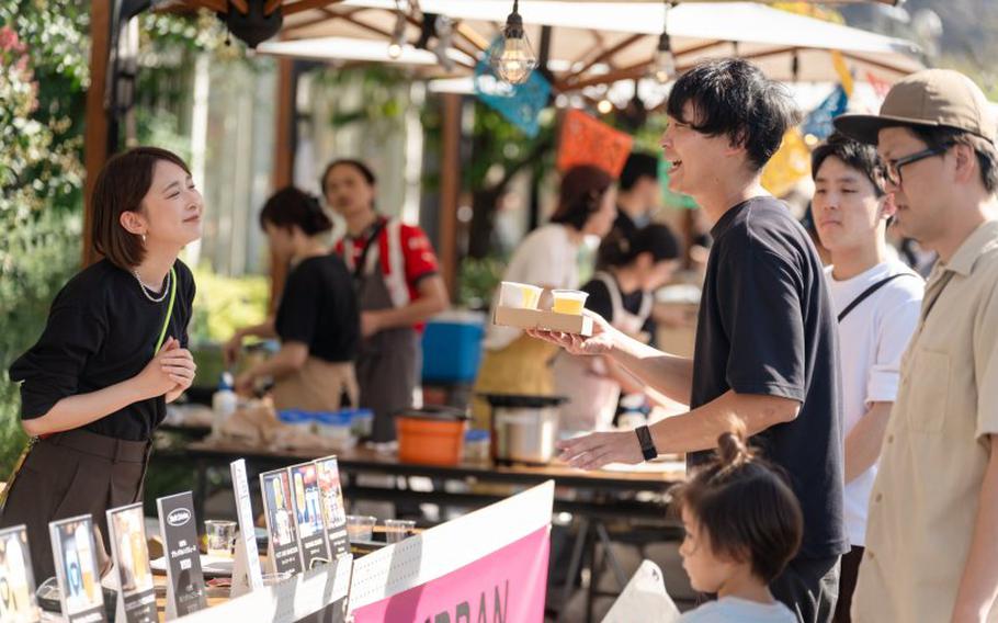 customers buying drinks at a booth outside.