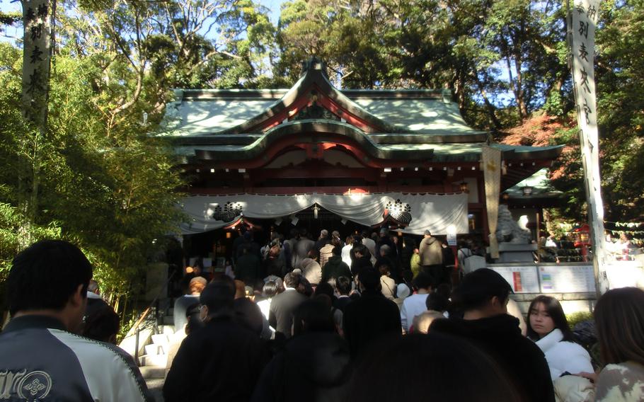 Visitors make a line to press the palms and fingers of both hands together at Kinomiya Shrine