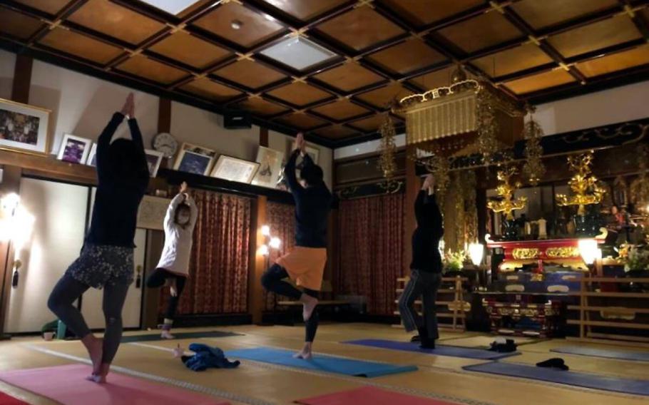 People enjoy yoga inside Kakurinbo’s temple hall.