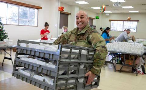 Photo Of U.S. Air Force Chief Master Sgt. Kenneth Hauck, 374th Airlift Wing command chief, carries pallets filled with cookies during the annual “Cookie Crunch” event at Yokota Air Base, Japan, Dec. 17, 2024. The Yokota community developed this tradition to lift spirits of base Airmen experiencing the holidays away from home by providing baked cookies during the holiday season. 