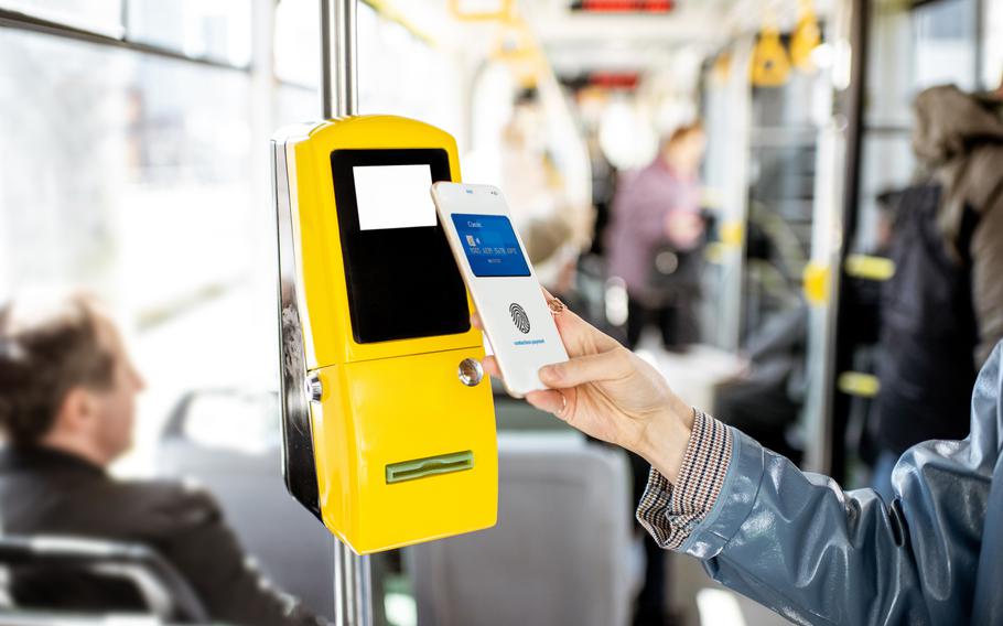 Paying conctactless with smartphone for the public transport in the tram, close-up view