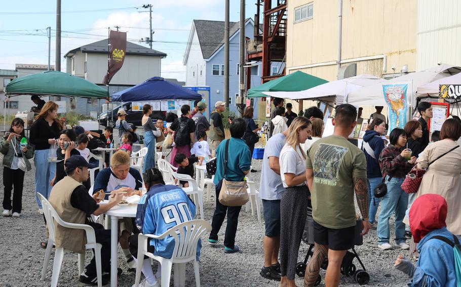 People are enjoying themselves with booths at a vacant lot.