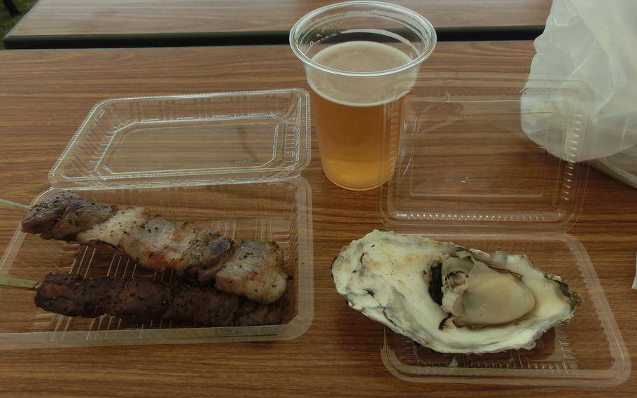 Oyster and skewered local beef and pork, and beer are on the table.