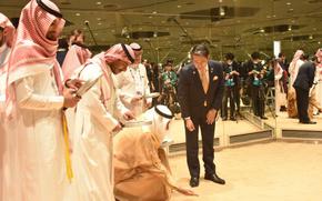 One of the members from Saudi Arabia is squatting and checking the quality of the sands in the exhibit.