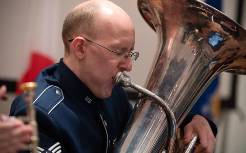 Photo Of U.S. Air Force Staff Sgt. Colby Parker with his eyes closed is playing the instrument.