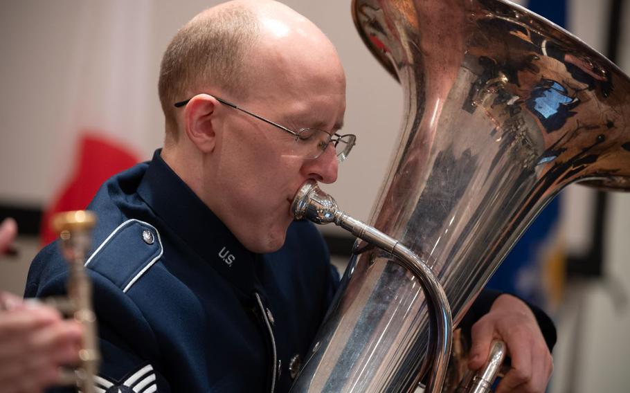 U.S. Air Force Staff Sgt. Colby Parker with his eyes closed is playing the instrument.