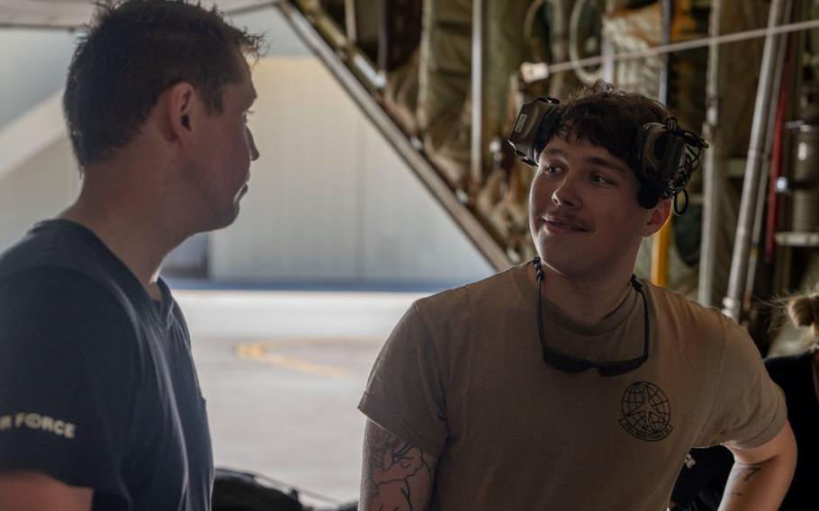 U.S. Air Force Airman 1st Class Dayton Warf speaks to a Royal Australian Air Force member.