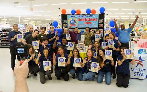 Photo Of Yokota Main Exchange staff group photo as Stars and Stripes Pacific Commander Lt. Col. Marci Hoffman presents award.