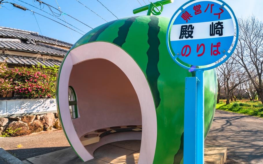 kyushu, japan - december 10 2021: Metal panel of the Tonozaki bus stop on the Highway 207 of Konagai town in front of the famous giant watermelon fruit of the Tokimeki Fruit-shaped Bus Stop Avenue.