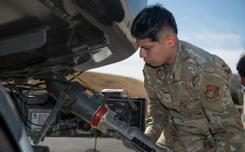 Photo Of 1st Class Juan Aparicio connects a fuel hose.