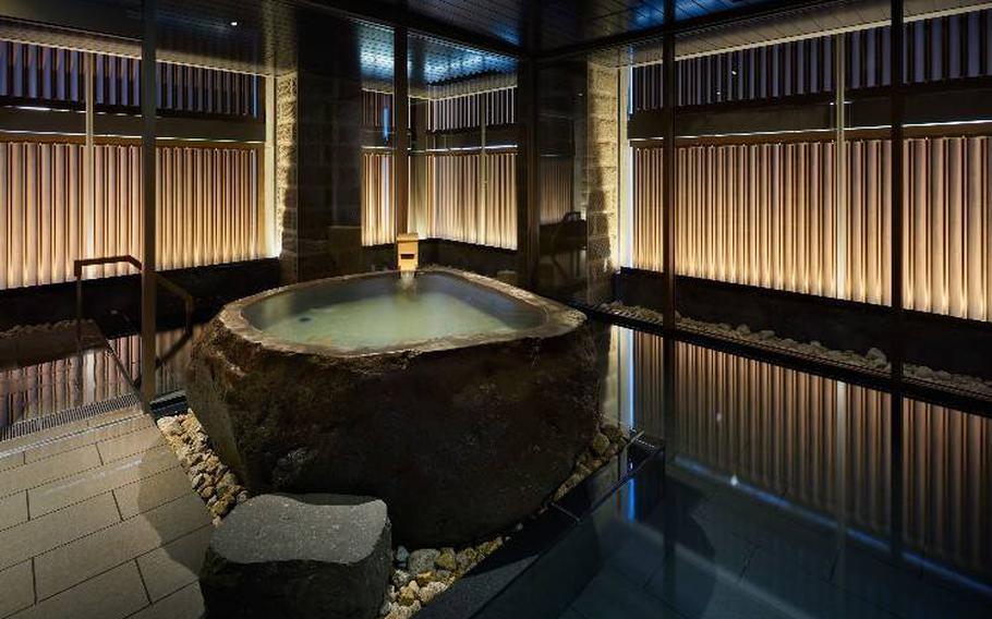 The large bath features subdued lighting and a relaxed atmosphere.