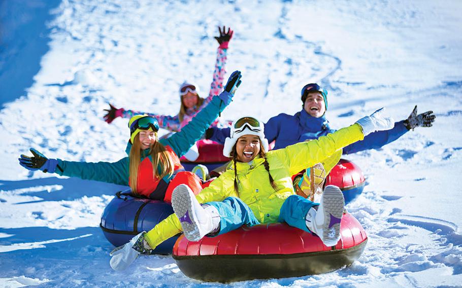 People enjoy riding tubes on a snow mountain.
