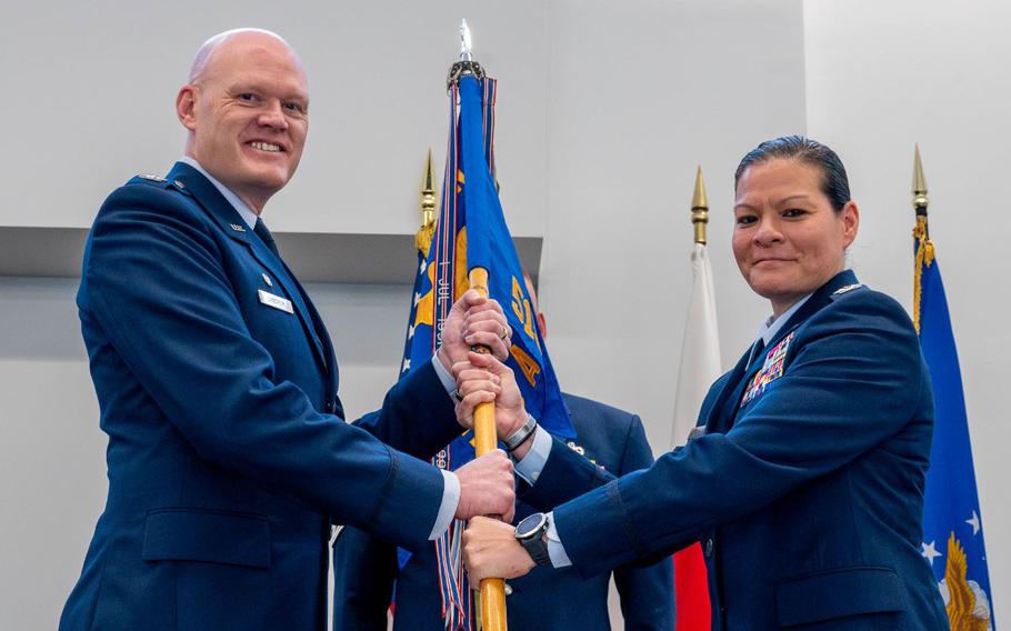 U.S. Air Force Col. Jens Lyndrup, 515th Air Mobility Operations Wing commander, left, presents the guidon to Col. Cataleya Carlson, 515th Air Mobility Operations Group incoming commander.