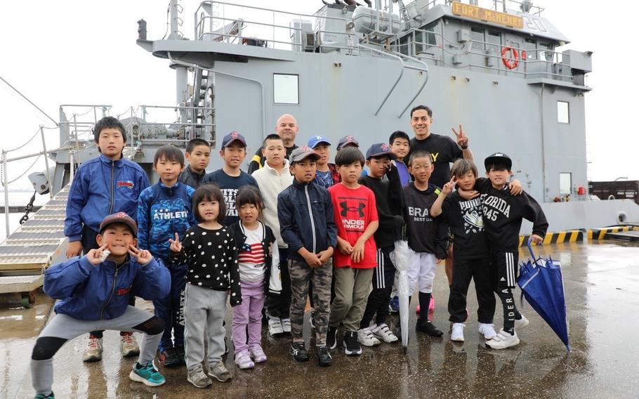 Soldiers assigned to the 5th Transportation Company at Yokohama North Dock pose for a photo together with a group of local children they invited to the installation May 6 for an inaugural sports exchange event. 