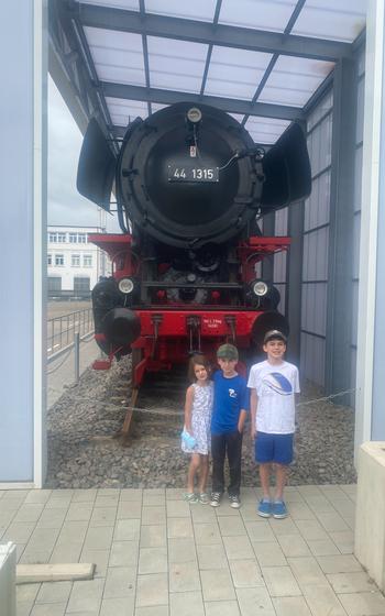 Richard and his siblings pose for a photo in front of a steam train.