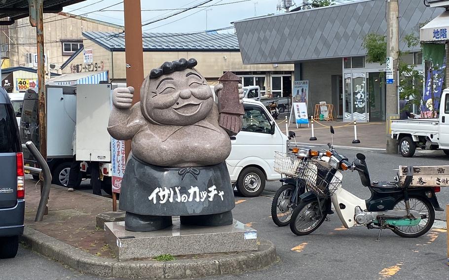 A statue that holds a squid in its left hand.